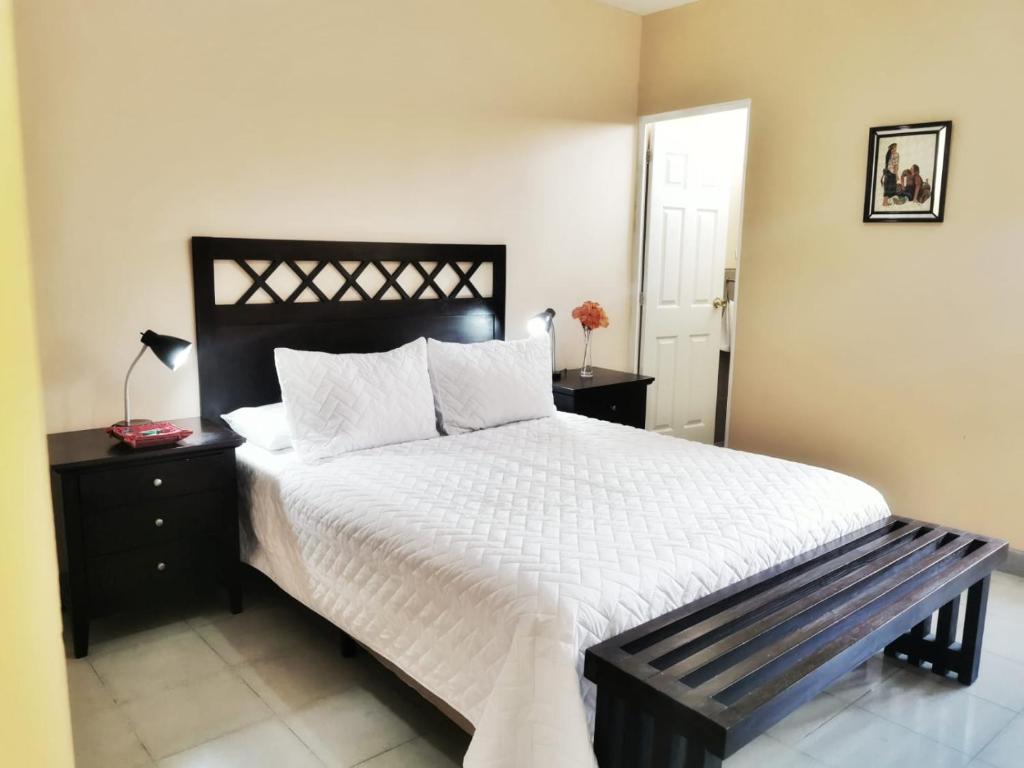 危地马拉Casa Mesa的一间卧室配有一张大床,旁边设有长凳