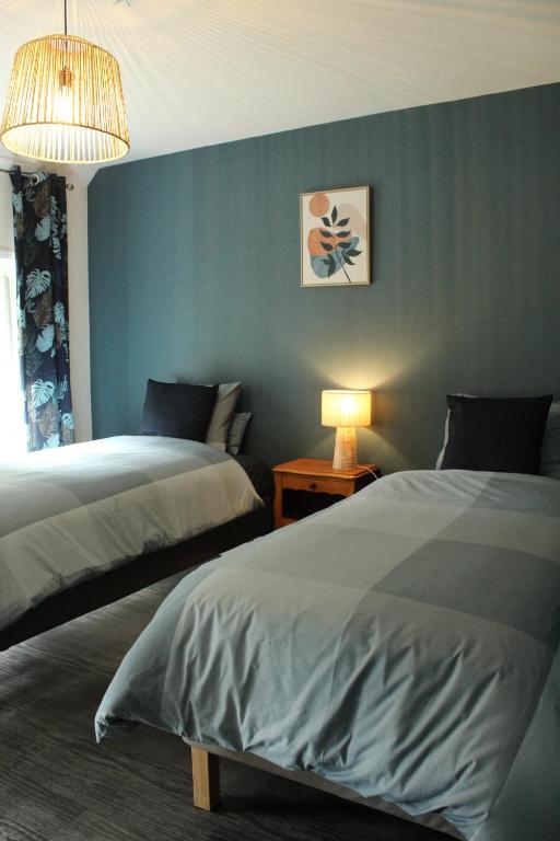 Wargnies-le-GrandGîte La Riviera的一间卧室设有两张床和蓝色的墙壁