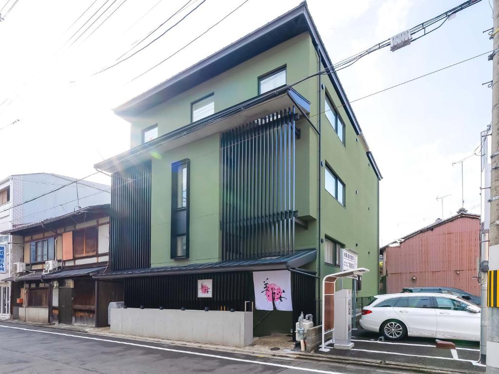 京都Kyoto inn Mio的一座五彩缤纷的建筑,前面有一辆汽车