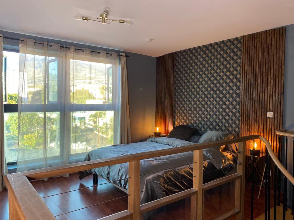 圣丹尼斯LOFT DIONYSIEN DE STANDING的一间卧室设有一张床和一个大窗户