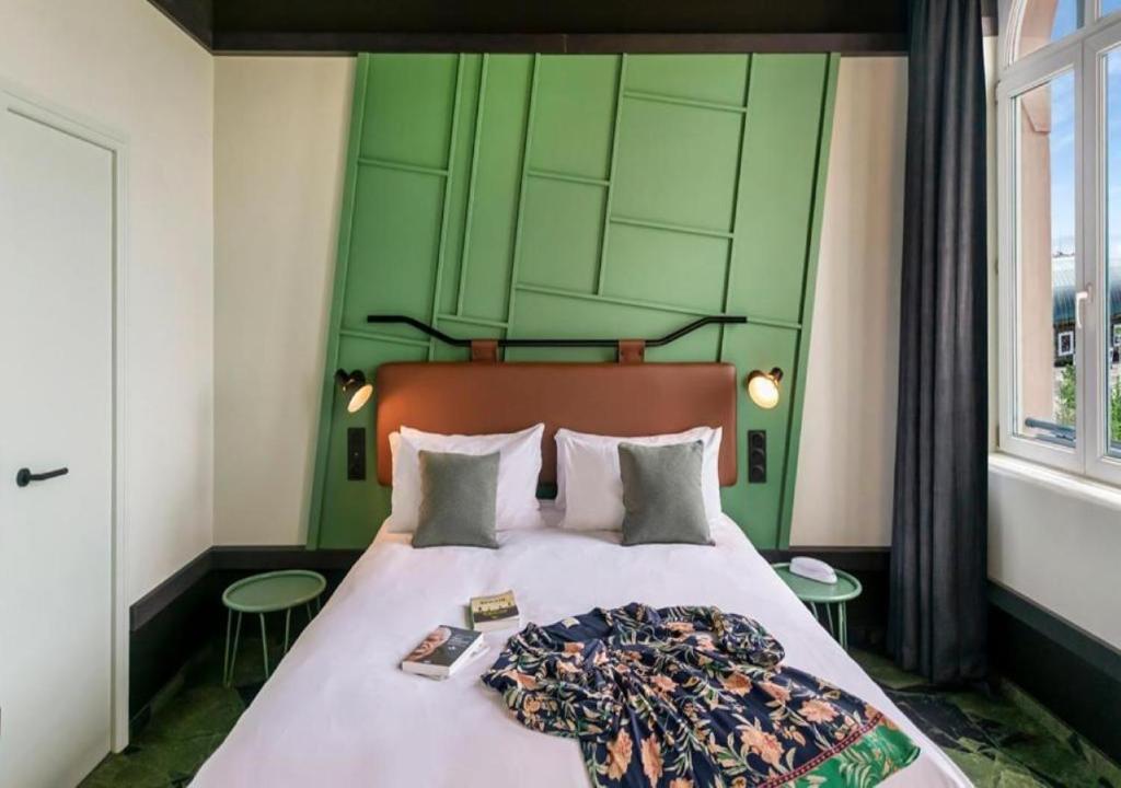 斯特拉斯堡Hôtel Tandem - Boutique Hôtel的一间卧室配有一张带绿色床头板的床