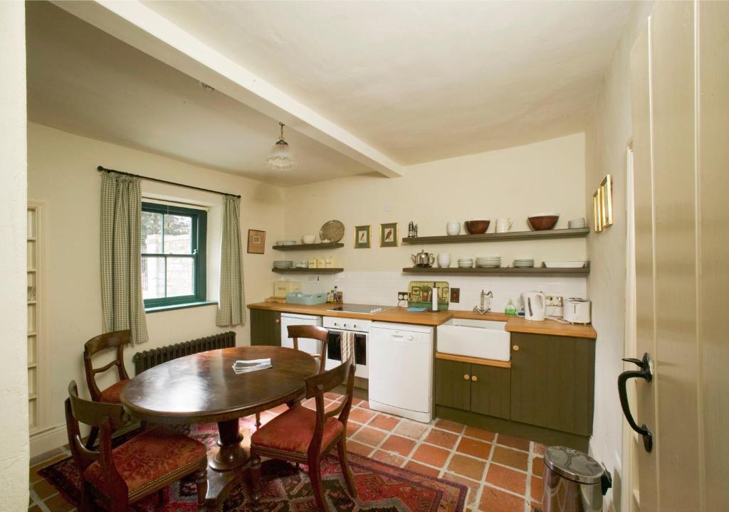 塞尔布里奇Castletown Gate House的厨房配有桌子和桌椅