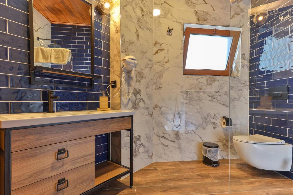 契拉勒Azur Hotel的浴室设有水槽、卫生间和蓝色瓷砖。