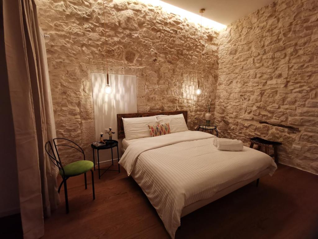卡萨诺德莱穆尔杰Aracoeli 20的一间卧室设有一张床和石墙