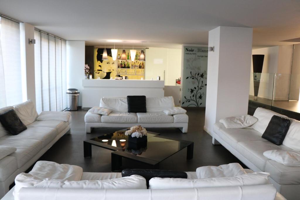 波米利亚诺达尔科HOTEL QUADRIFOGLIO的客厅配有白色沙发和咖啡桌