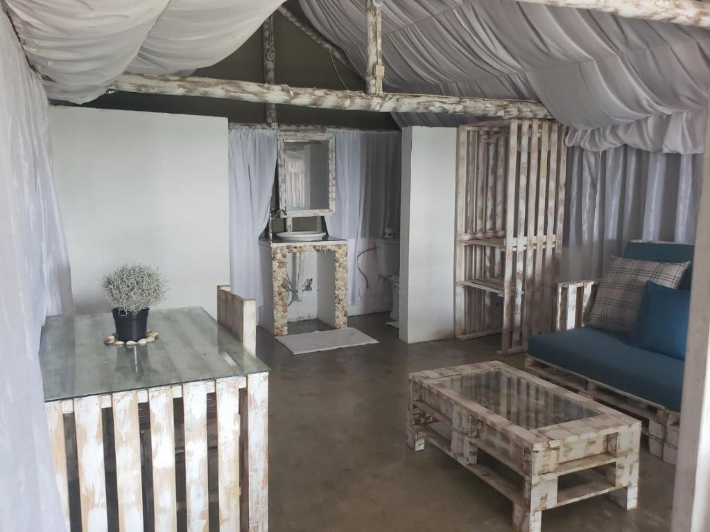 蓬塔杜欧鲁Complexo Baleia Azul Camping的客厅配有蓝色的沙发和桌子