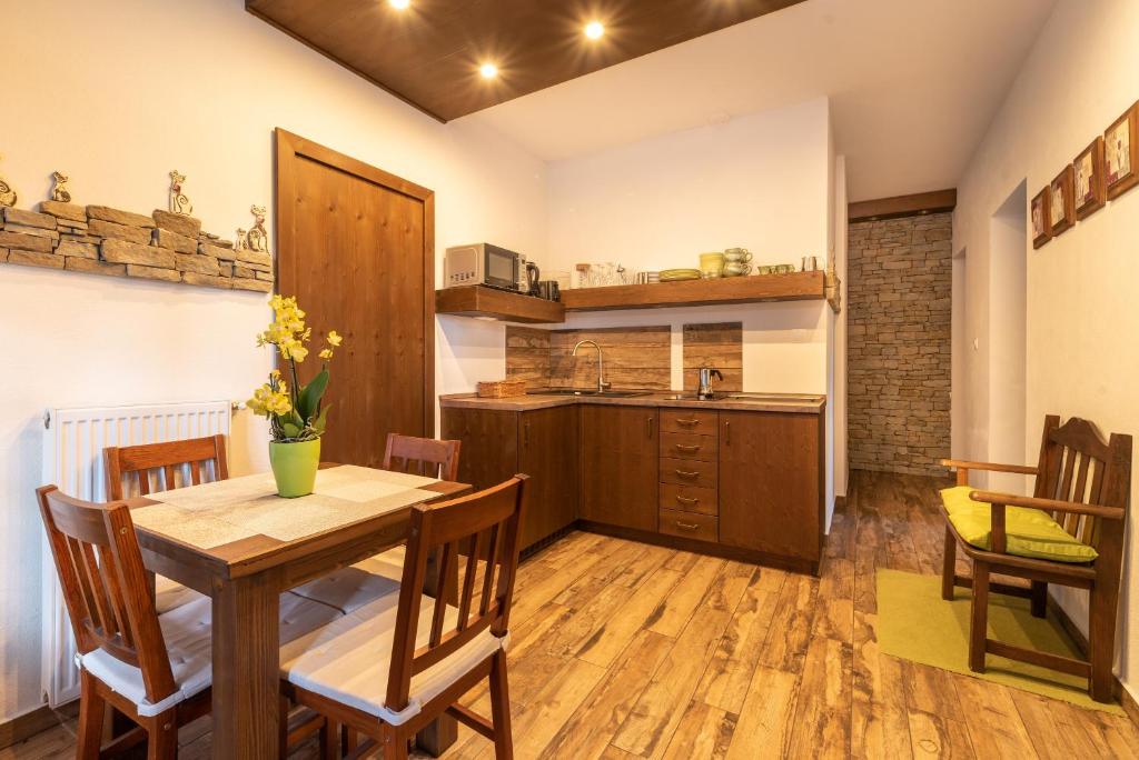 巴拉通尤洛克Juhar Apartmanház的厨房以及带木桌和椅子的用餐室。