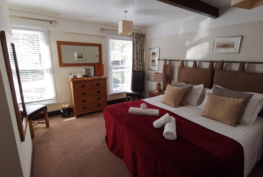 凯西克The Langstrath Country Inn的一间卧室配有一张大床和两条毛巾