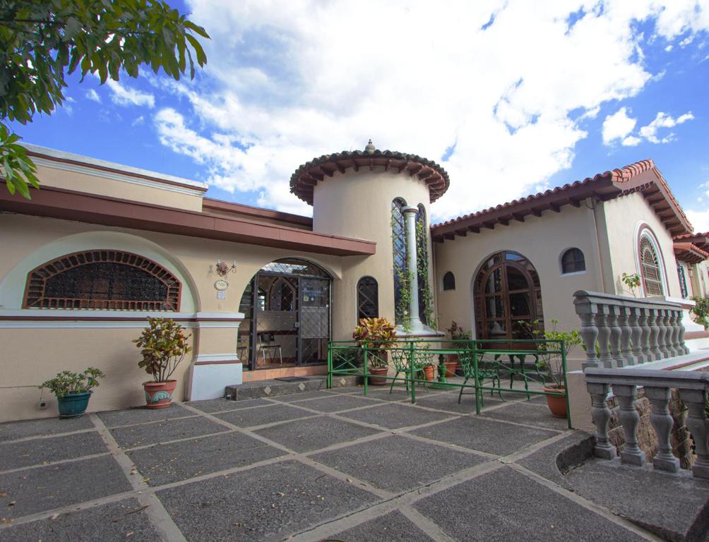 圣萨尔瓦多塞伦娜埃斯卡隆别墅酒店的前面有两张绿色长椅的房子