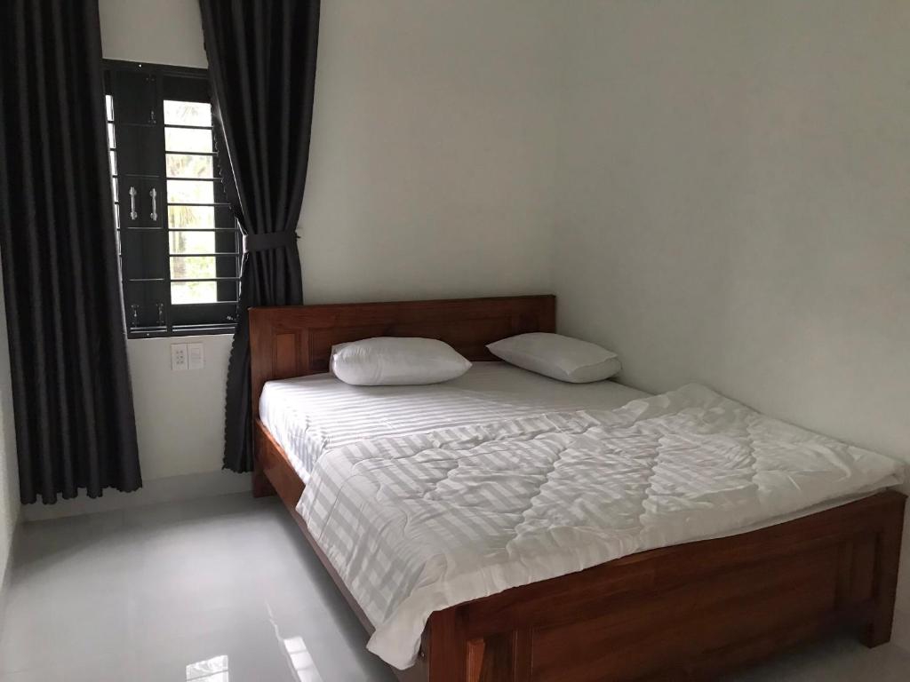 Vinh HoaThanh Tuan Motel的一间卧室配有一张带白色床单的床和一扇窗户。