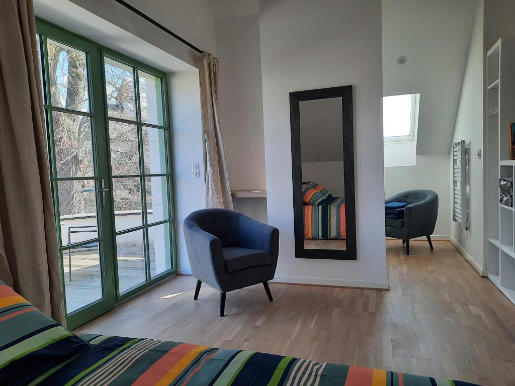 RévillonLE RELAIS的一间卧室配有镜子、椅子和一张床