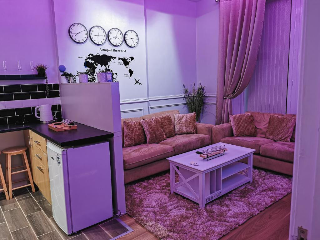 格拉斯哥LUXURIOUS 3 BEDROOM APARTMENT: HEART OF WESTEND的紫色的客厅配有沙发和桌子