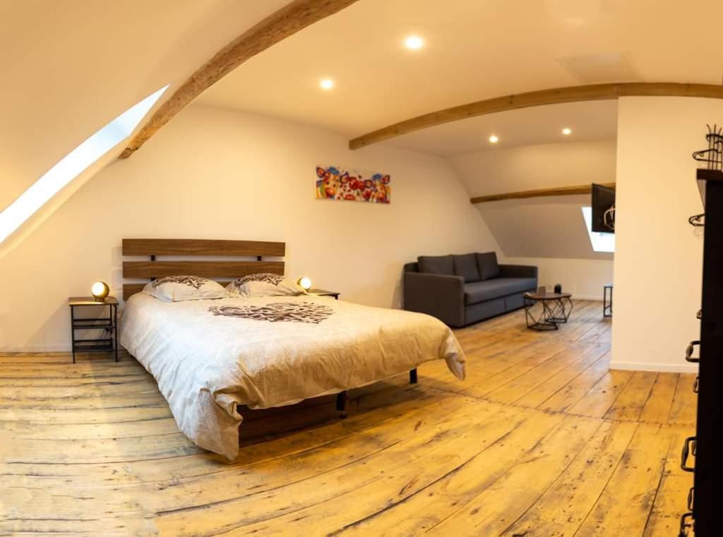 Saint-Germain-des-FossésCYRIS - Chambres Duplex - Spa & Piscine Centre ville的一间卧室配有一张床和一张沙发