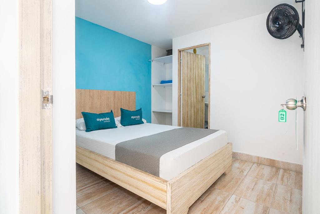 麦德林Ayenda Malaki的一间卧室配有一张蓝色墙壁的床