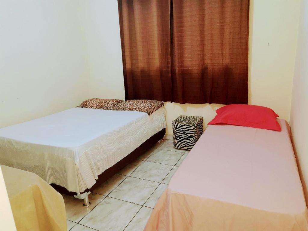 隆德里纳Casa amarela 02 jdm moema的客房设有两张床和窗户。