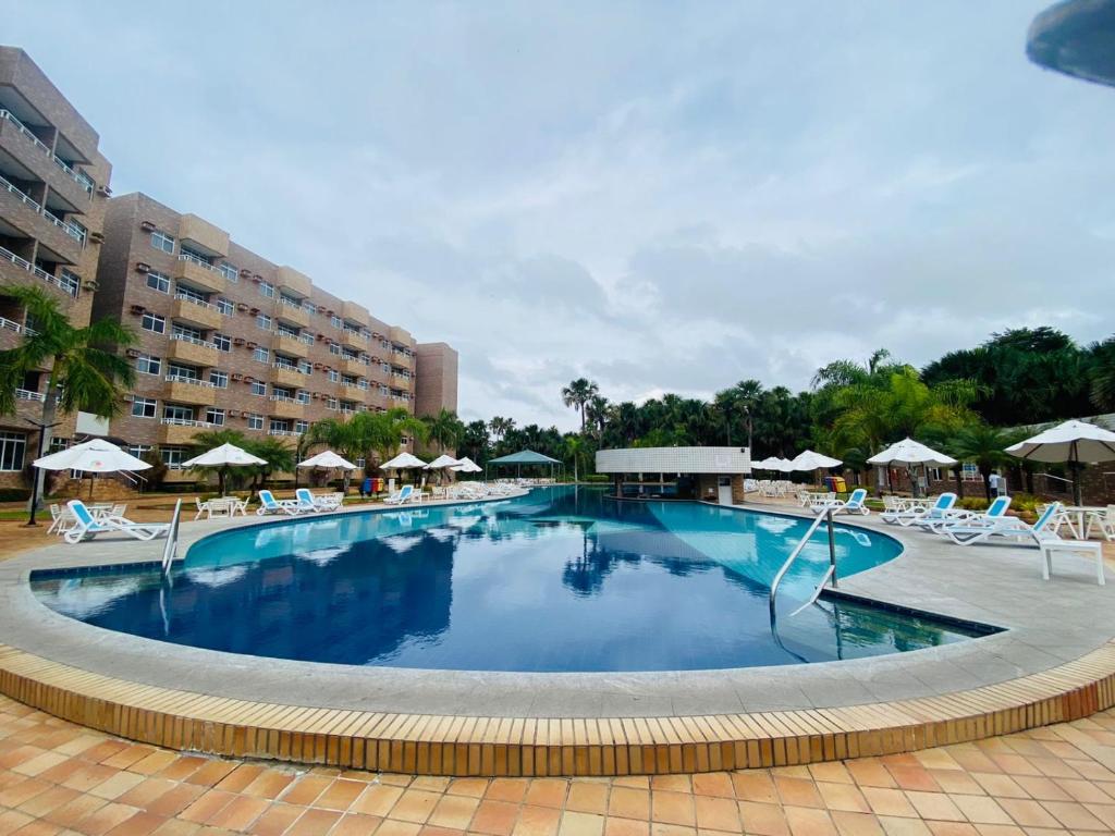 巴雷里尼亚斯Gran Lençóis Flat Residence的一个带椅子和遮阳伞的大型游泳池