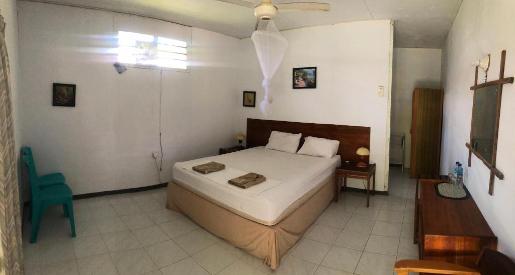 NolothMahu Lodge的一间卧室,卧室内配有一张床和一把椅子