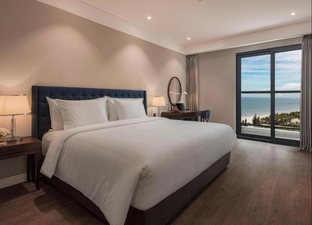 岘港Luxury Apartment in Sheraton Building with Ocean View的一间卧室设有一张大床和一个大窗户