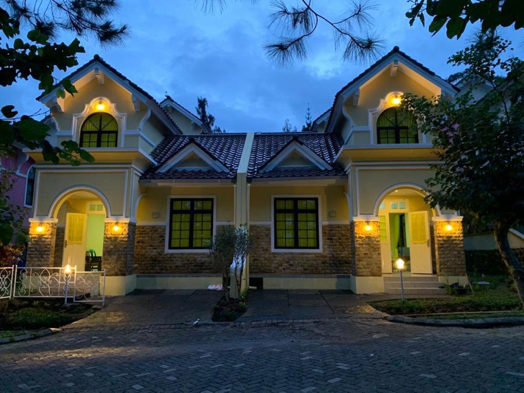 展玉Villa Kota Bunga 2 kamar full wifi harga budget的一座带灯的白色大房子