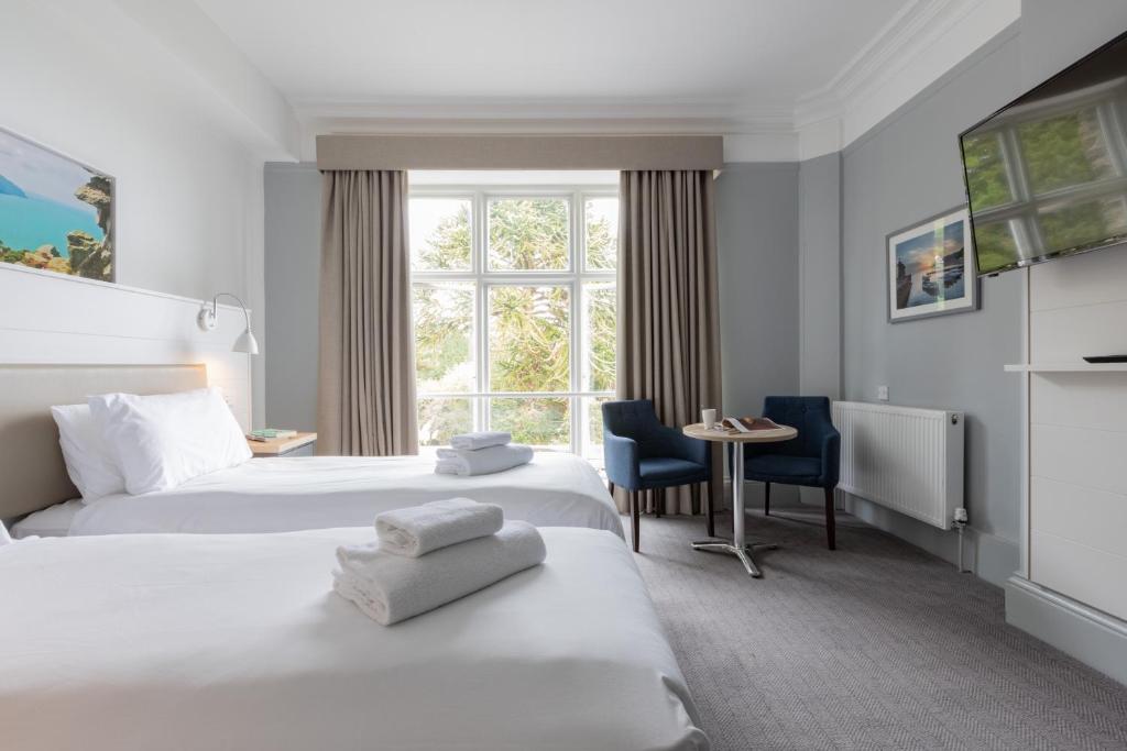 林顿The Valley of Rocks Hotel的酒店客房设有两张床和窗户。
