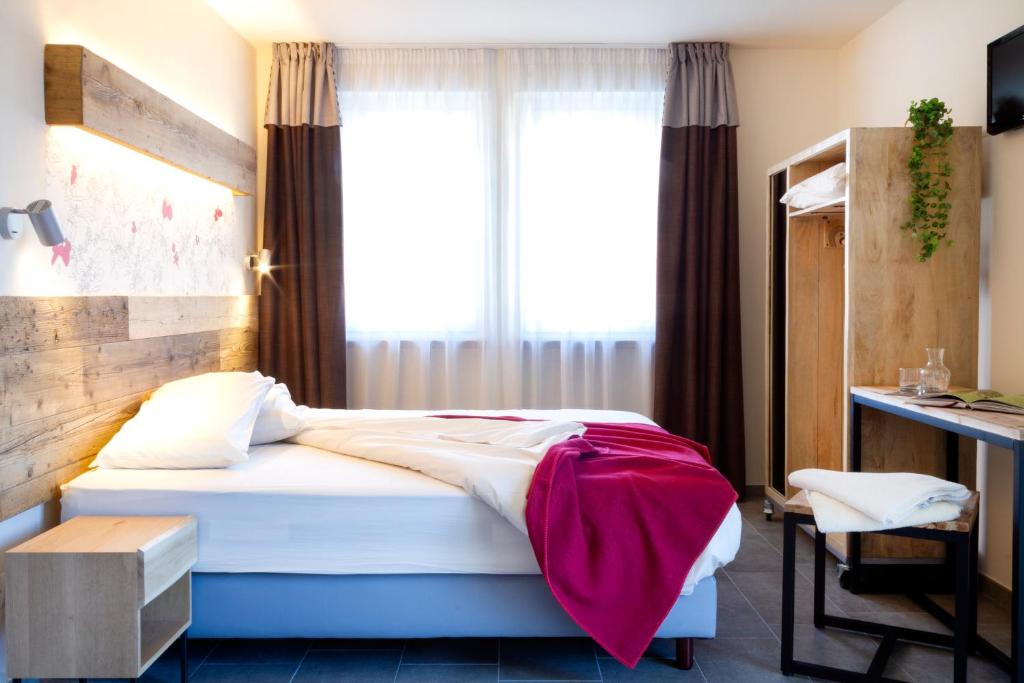 奥斯塔Hirondelle Locanda的一间卧室配有一张床、一张书桌和一个窗户。