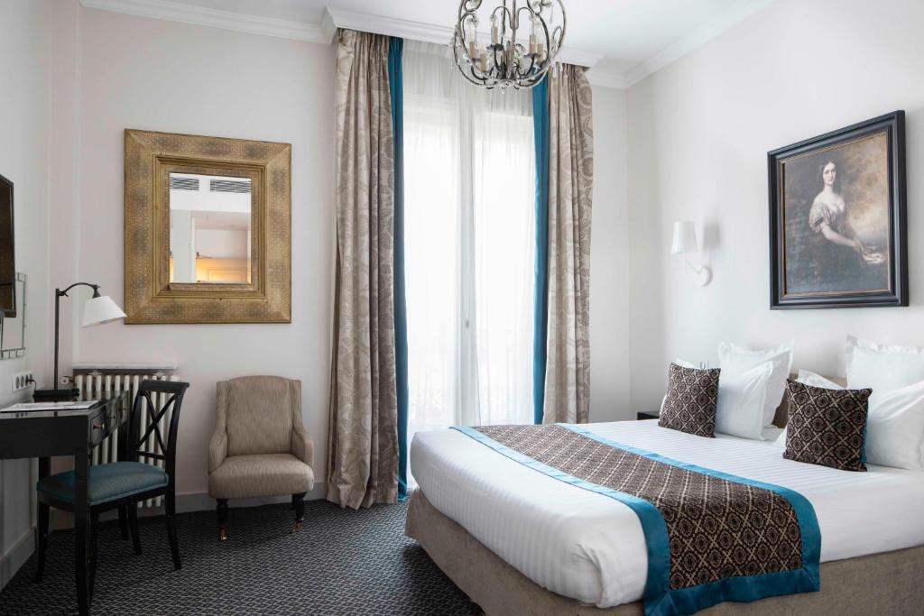 巴黎阿斯托利亚布拉德福德酒店的酒店客房配有一张床、一张桌子和一把椅子。