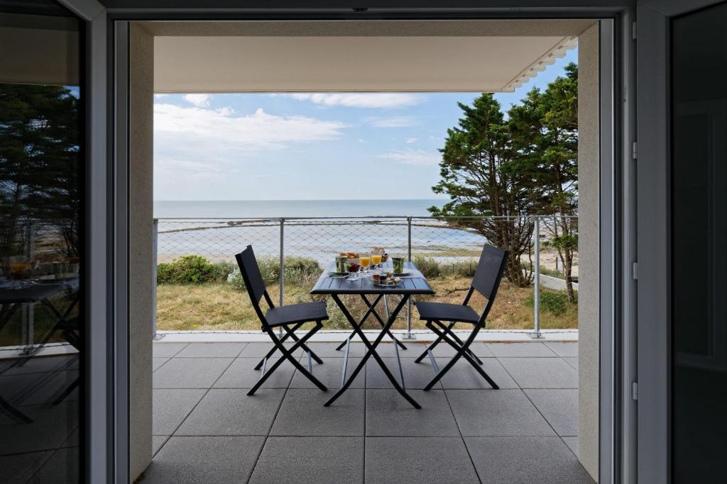 拉盖里尼耶尔Superbe appartement neuf face plage sur l ile de Noirmoutier的海景阳台上的桌椅
