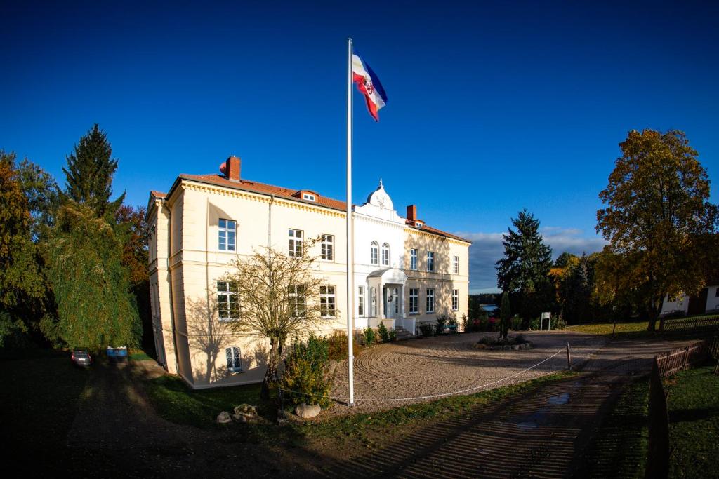 DaschowLandhotel Schloss Daschow的白色建筑前柱上的旗帜