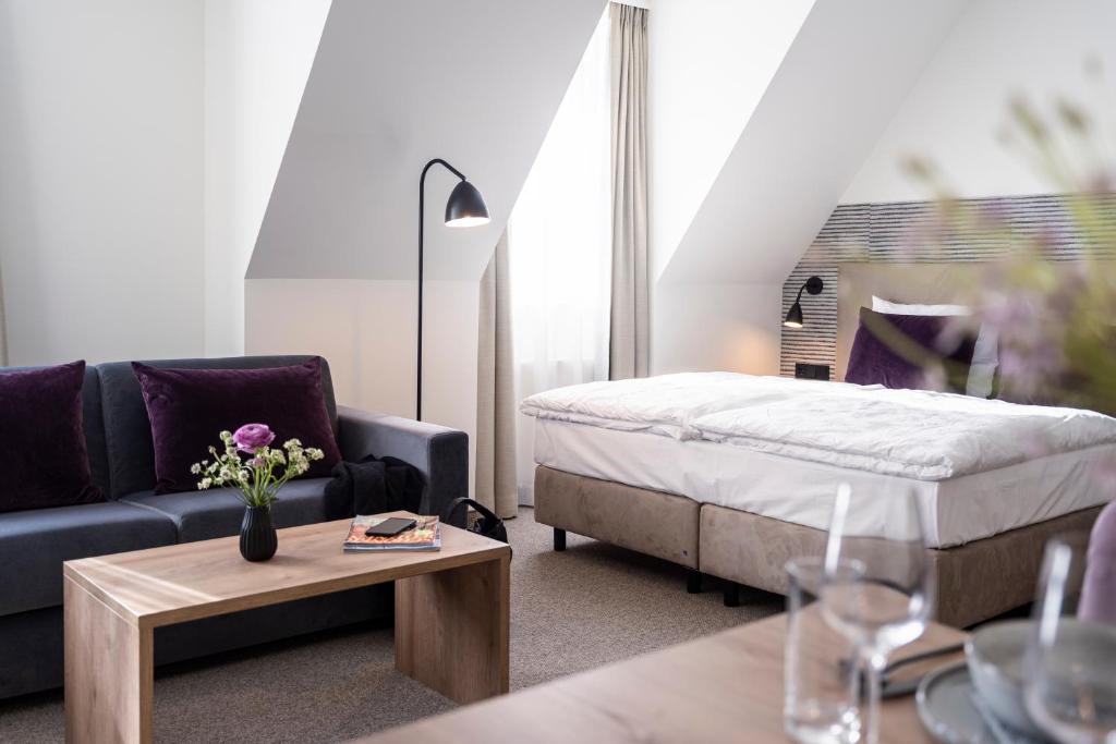 施特拉尔松德maakt Hotel的客厅配有床、沙发和桌子