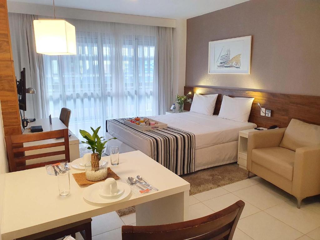 巴西利亚费欧逊赫普拉斯酒店的酒店客房,配有一张床、一张桌子和椅子