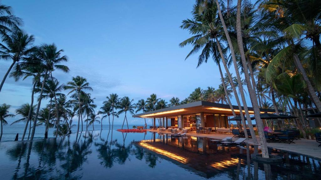 泰巴Carmel Taíba Exclusive Resort的棕榈树和游泳池度假村