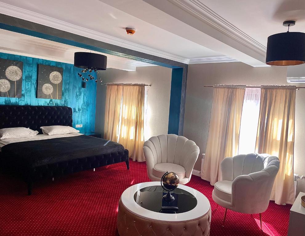 加拉茨Hotel City Break的一间卧室配有一张床、两把椅子和一张桌子