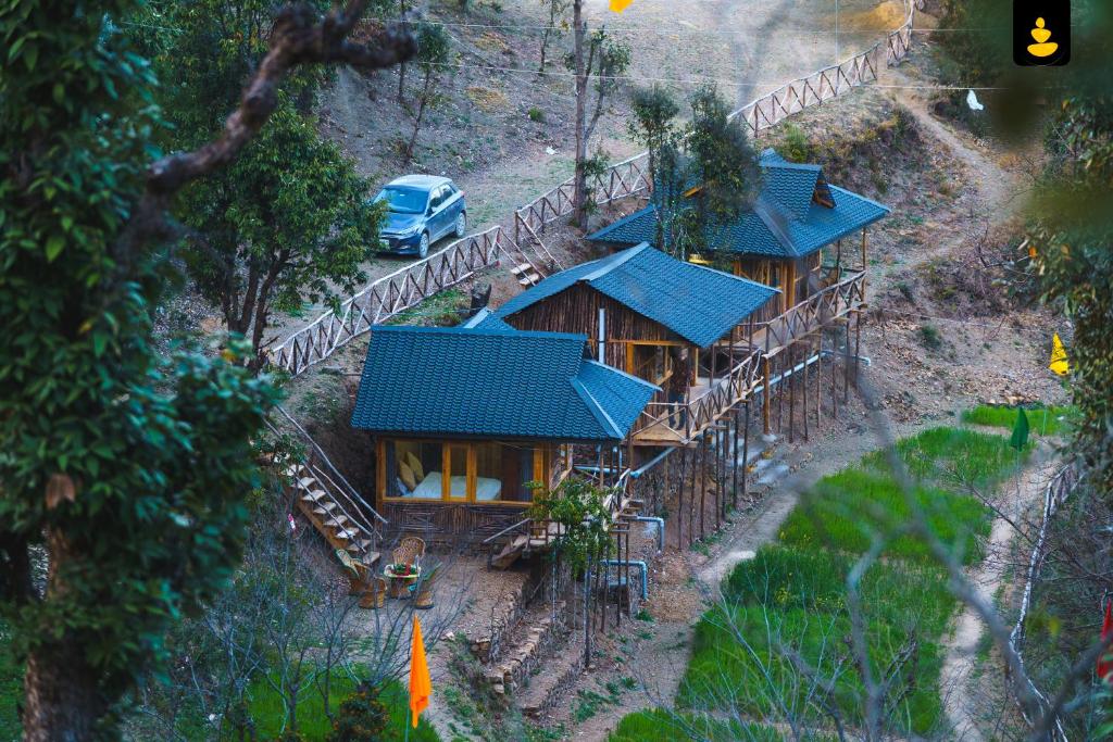 西姆拉LivingStone Shimla Jungle Stay的享有蓝色屋顶房屋的顶部景色