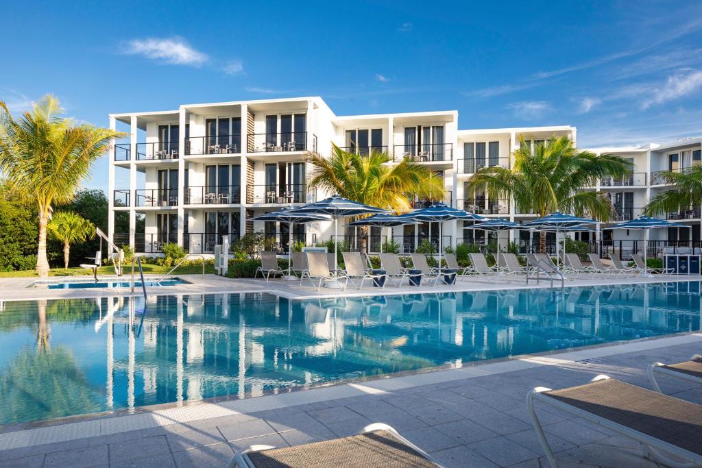 基韦斯特The Capitana Key West的一个带椅子和遮阳伞的游泳池的度假酒店