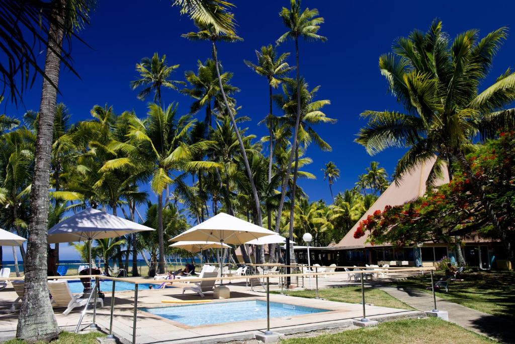 延根科洛村酒店的一个带游泳池和棕榈树的度假村