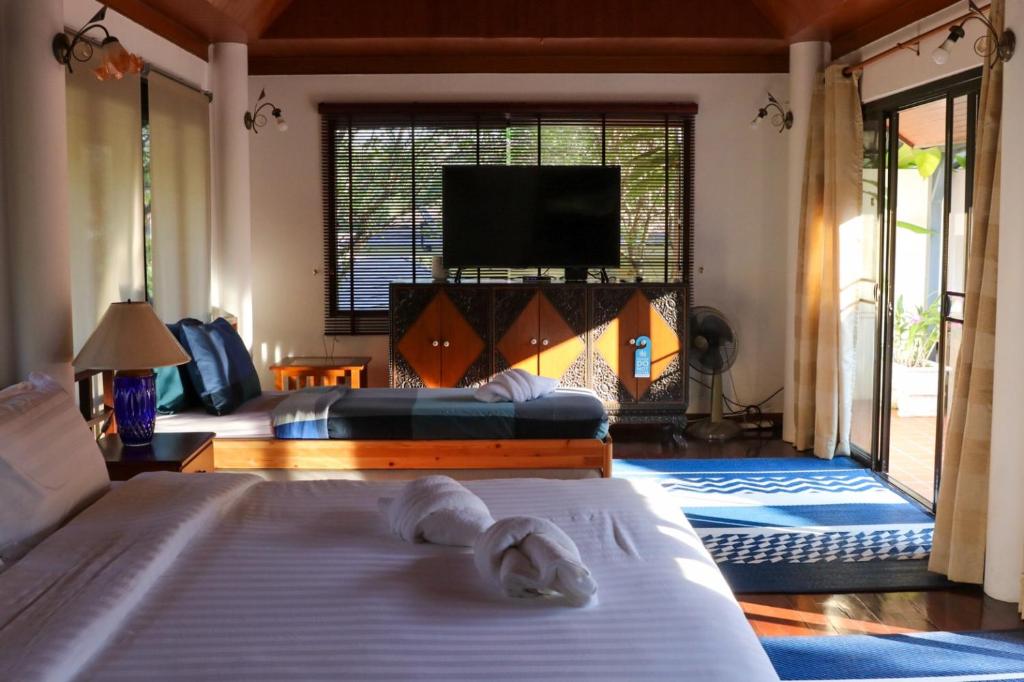 慕斯Casa Khaoyai Bed&Breakfast的一间卧室配有两张床和一台平面电视