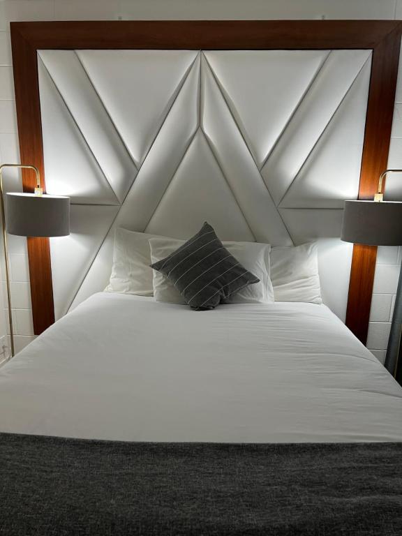 克利尔沃特Hotel Civilia Lakeside by Civilia Golf Retreat的卧室配有带两盏灯的白色床