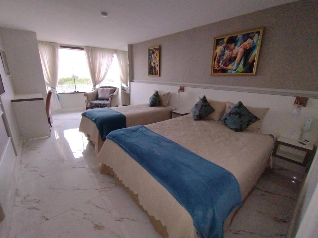 巴西利亚Antonio's Hotel e Spa - Airport的酒店客房设有两张床和窗户。