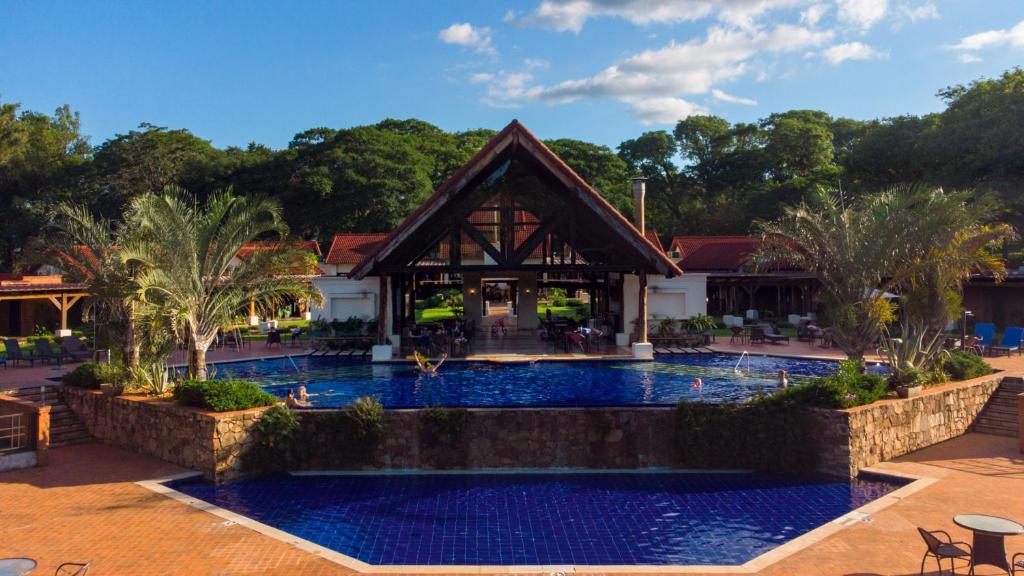 卡库佩上格拉西亚公园酒店 的一座带游泳池的度假村,位于一座建筑前