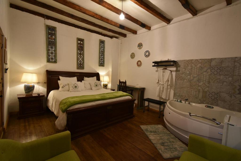 克萨尔特南戈Casa Morasan Hotel-Boutique的一间卧室配有一张床和浴缸