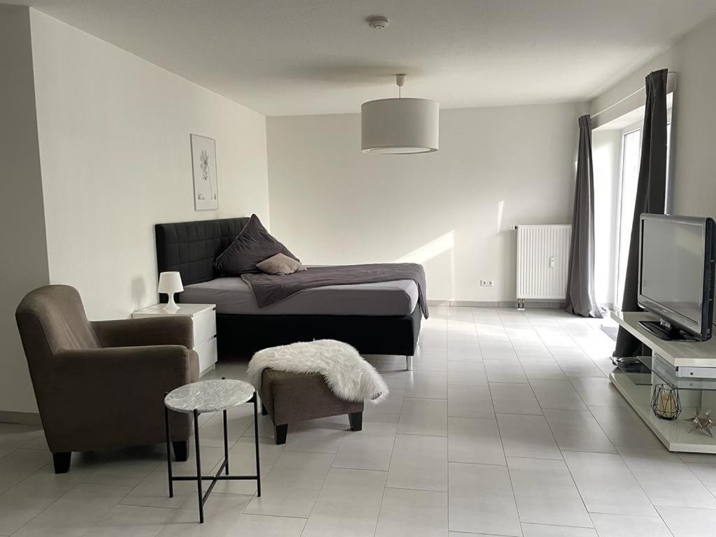 格拉德贝克Modernes Appartement的客厅配有床、椅子和电视