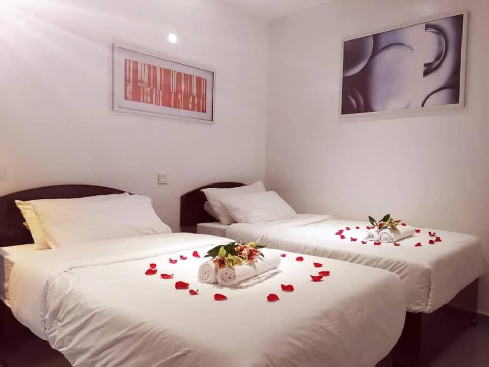 实兆远HOTEL MIRAMA 美麗華酒店的宿舍间的两张床,床单上有心