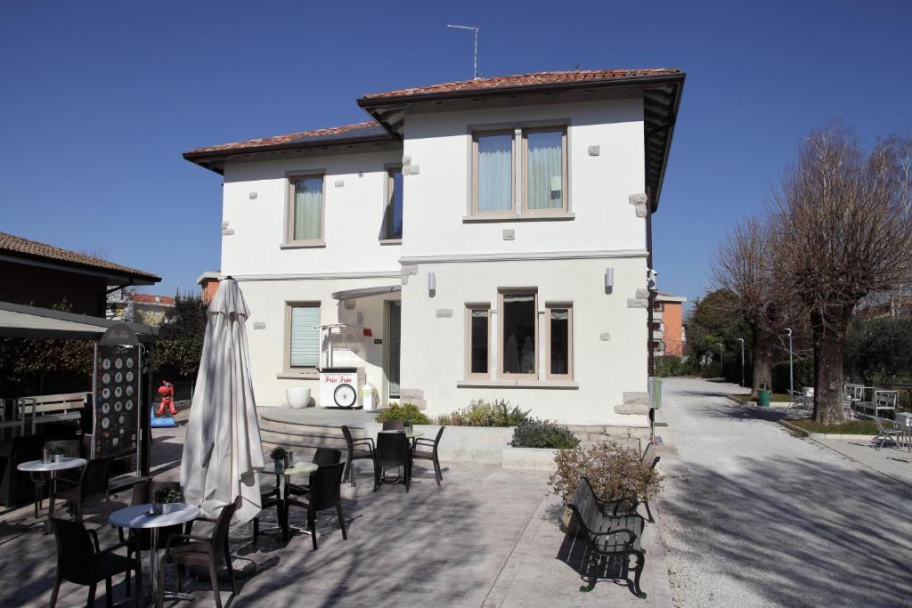 龙基德伊莱焦纳里residence villa Frio Frio的前面设有桌椅的白色房子