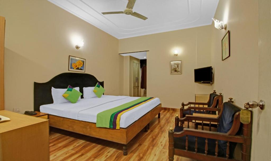 加尔各答Treebo Trend Mira Inn的一间卧室配有一张床、一张桌子和一把椅子