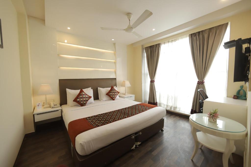 新德里Hotel Picasso Prive Naraina Delhi - Couple Friendly Local IDs Accepted的配有一张床、一张书桌和一扇窗户的酒店客房
