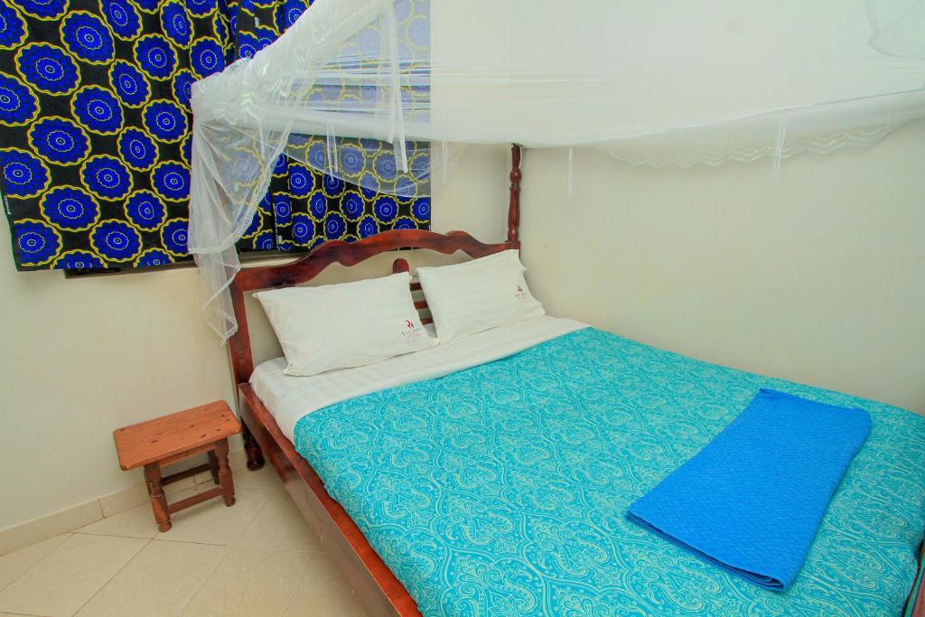 MbaleRichy Hotels and Safaris的小卧室配有一张带蓝色和白色床单的床