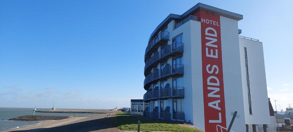 登海尔德兰兹艾德酒店的一座在海边有红白标志的建筑