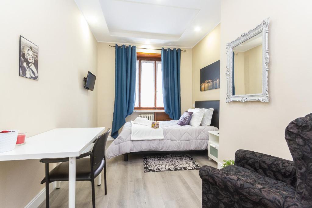 都灵Exclusive Room Arena Inalpi 'La casa di Bertino'的卧室配有1张床、1张桌子和1把椅子