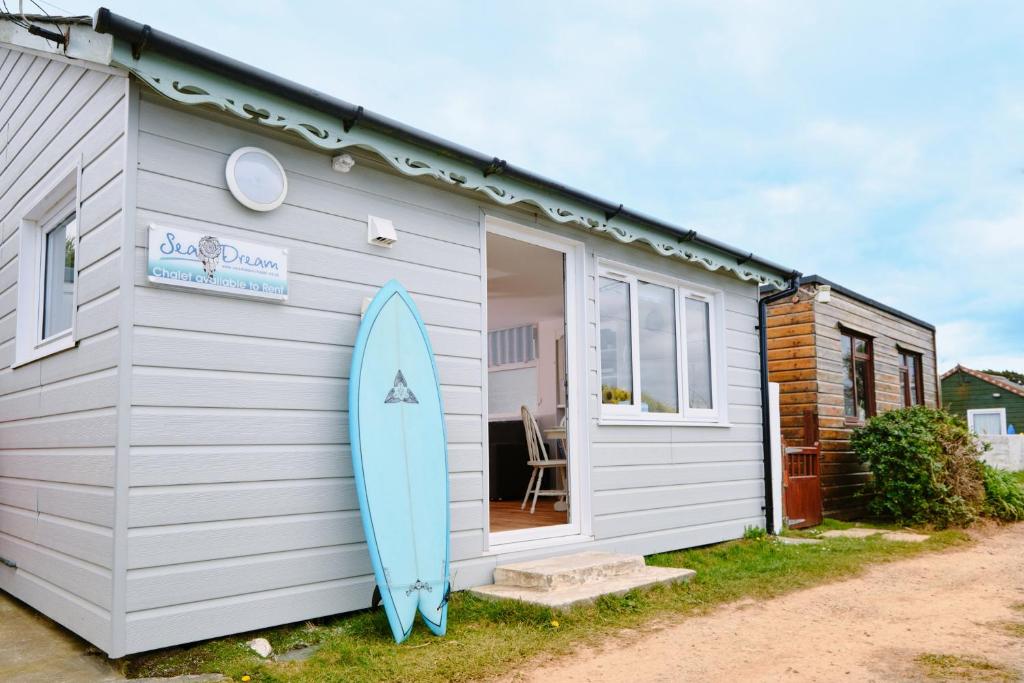 GwithianGwithian, Sea Dream Beach Chalet的冲浪板停在一个小房子外面