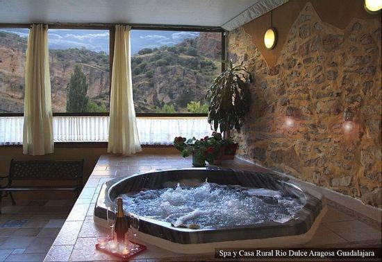 AragosaSpa y Casa Rural Rio Dulce的带大窗户的客房内的热水浴池